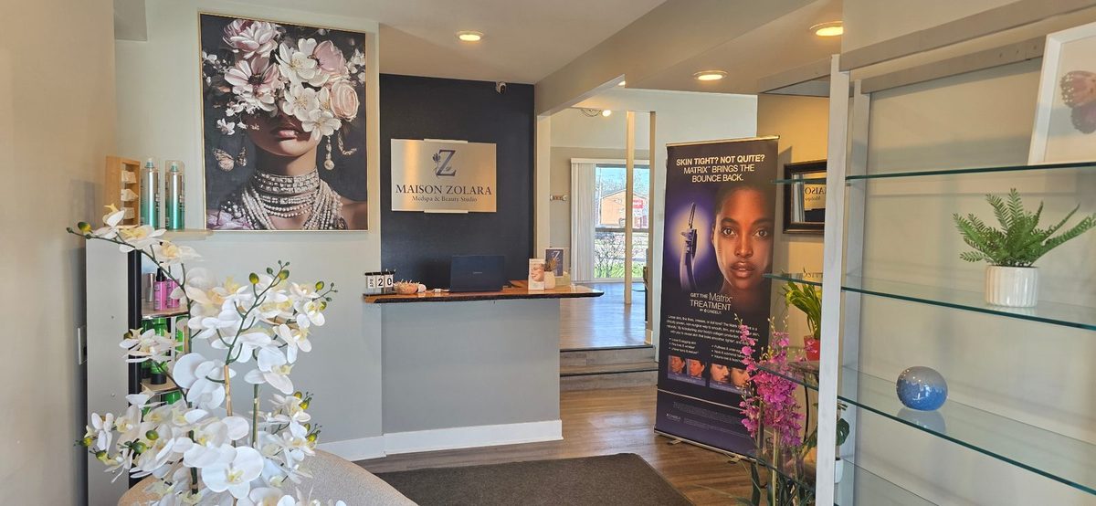 Reception – Maison Zolara Lansing Maison Zolara reception desk with floral artwork and Candela Matrix display in Lansing, Michigan