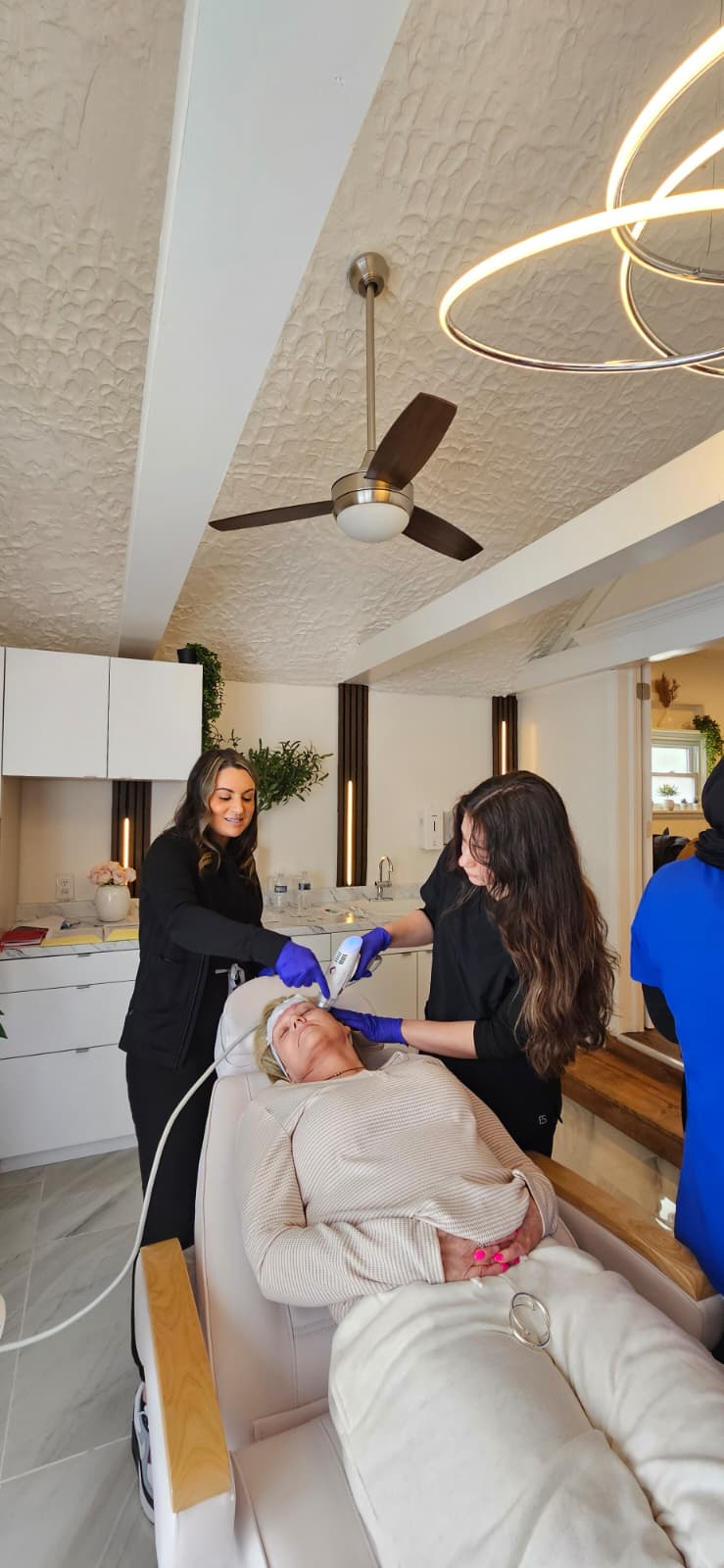 Wide view of Maison Zolara treatment room with Candela Matrix RF microneedling in progress, MD-supervised RN-administered